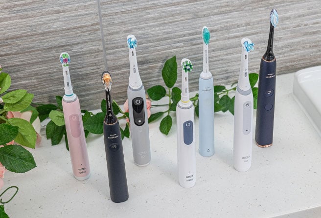 Various electric toothbrushes stood upright on a bathroom counter