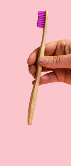 hand holding a bamboo toothbrush