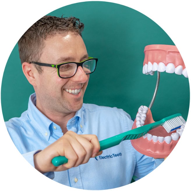 Jon brushing large dental model of mouth
