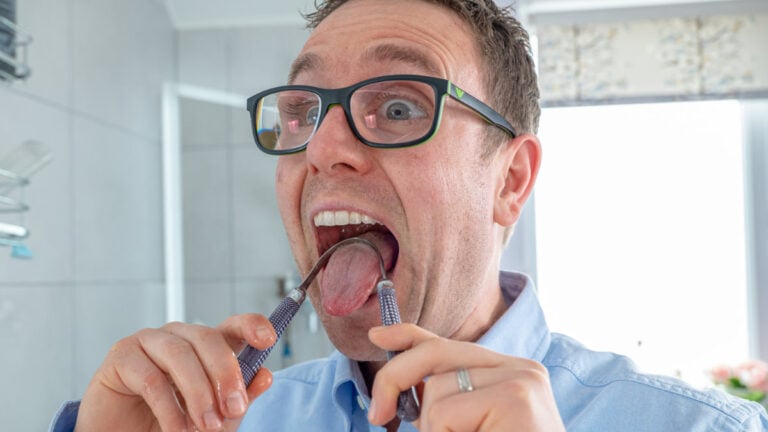 Man using tongue scraper