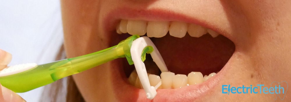 Person using floss holder to floss teeth