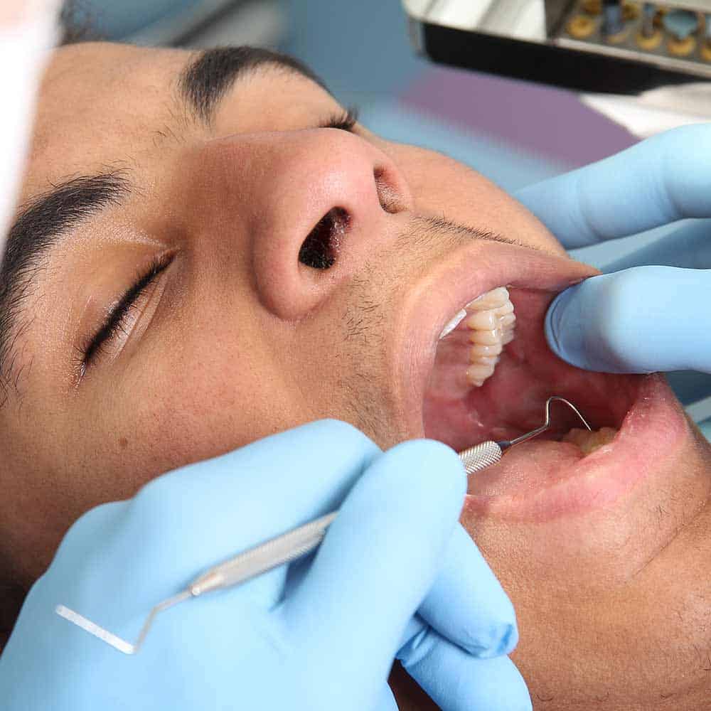 A dentist checking for cavities of a patient