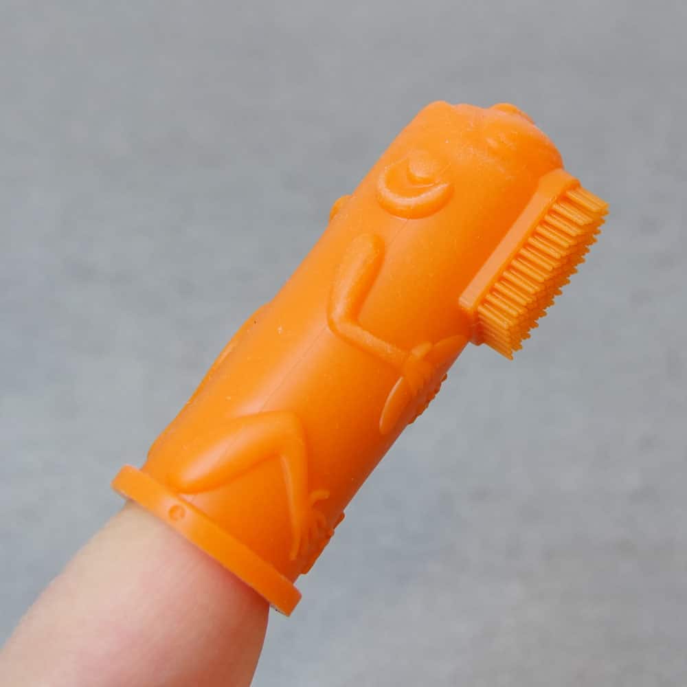 A close up shot of the Orange Brushies finger puppet toothbrush