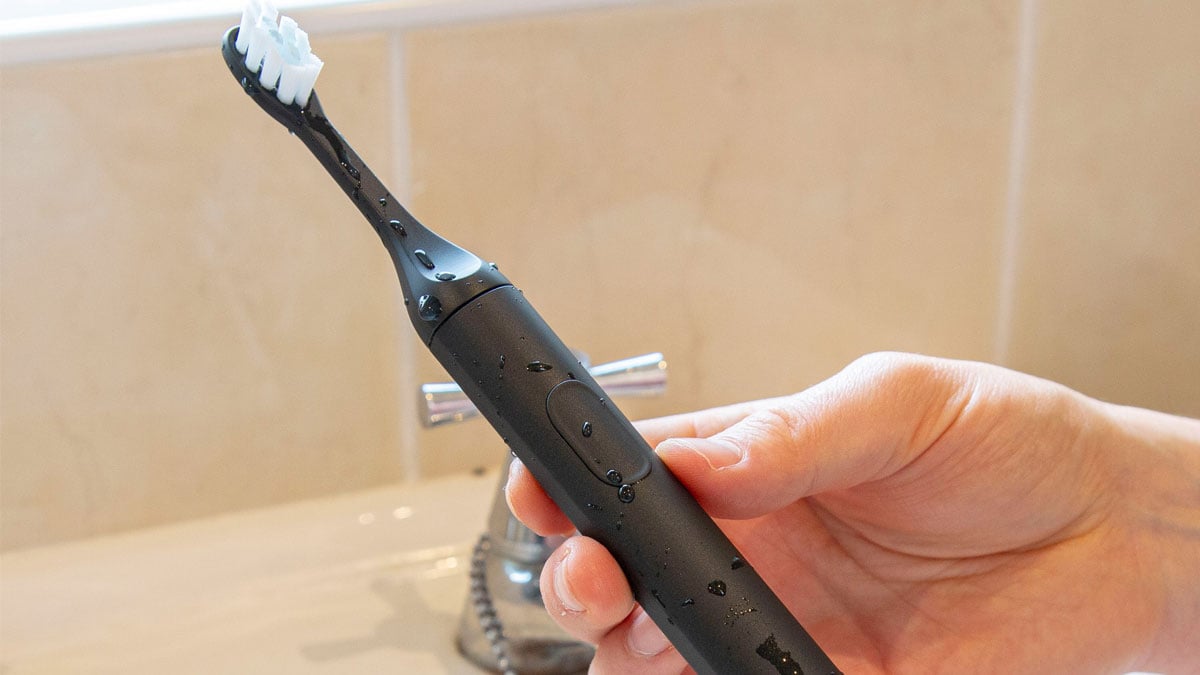 SURI toothbrush being held in hand in the bathroom