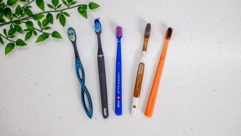 Five different types of manual toothbrush next to each other on worktop