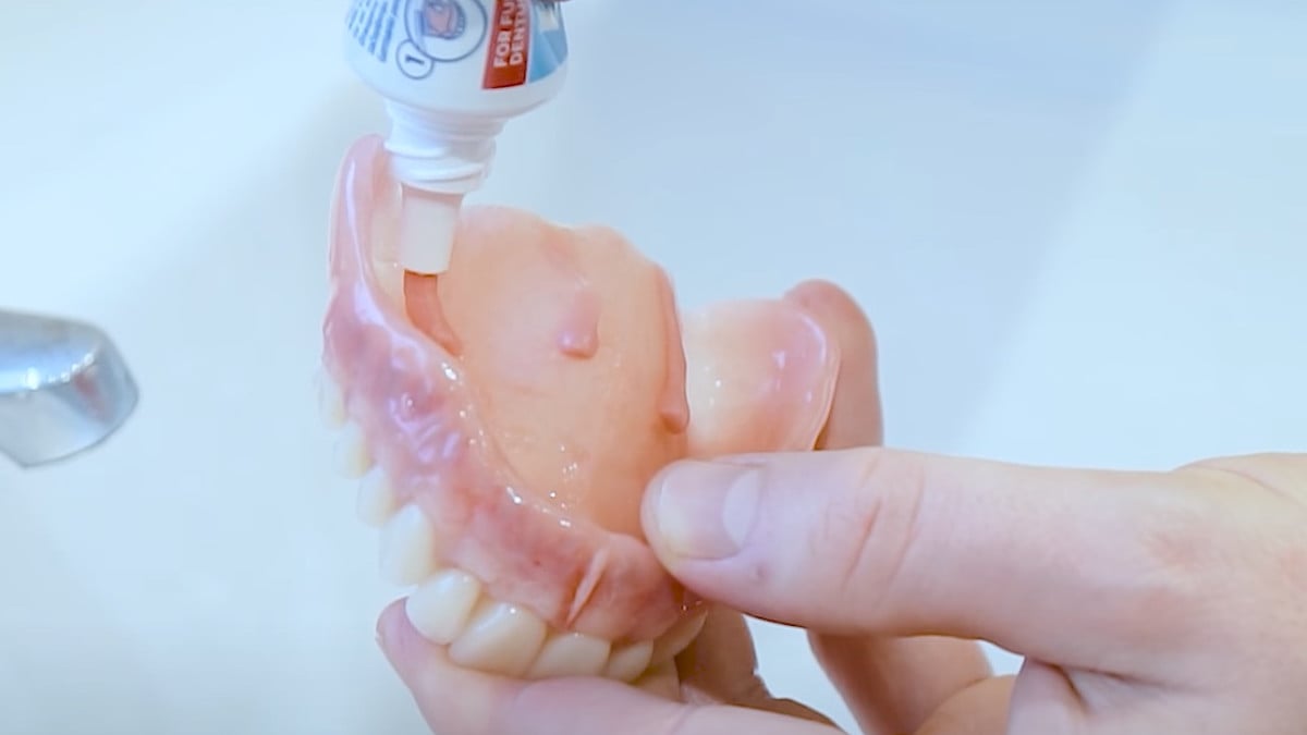 Denture adhesive being applied to denture