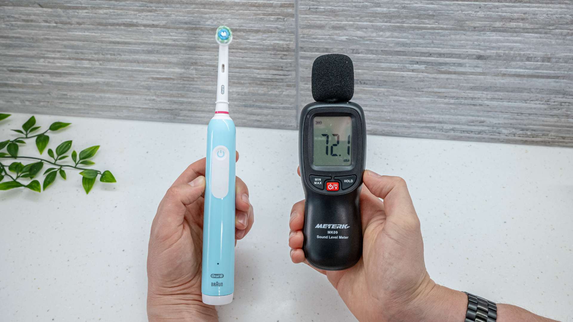 Oral-B toothbrush next to a decibel meter