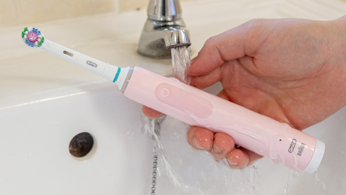 Oral-B Pro 3 being rinsed under running water