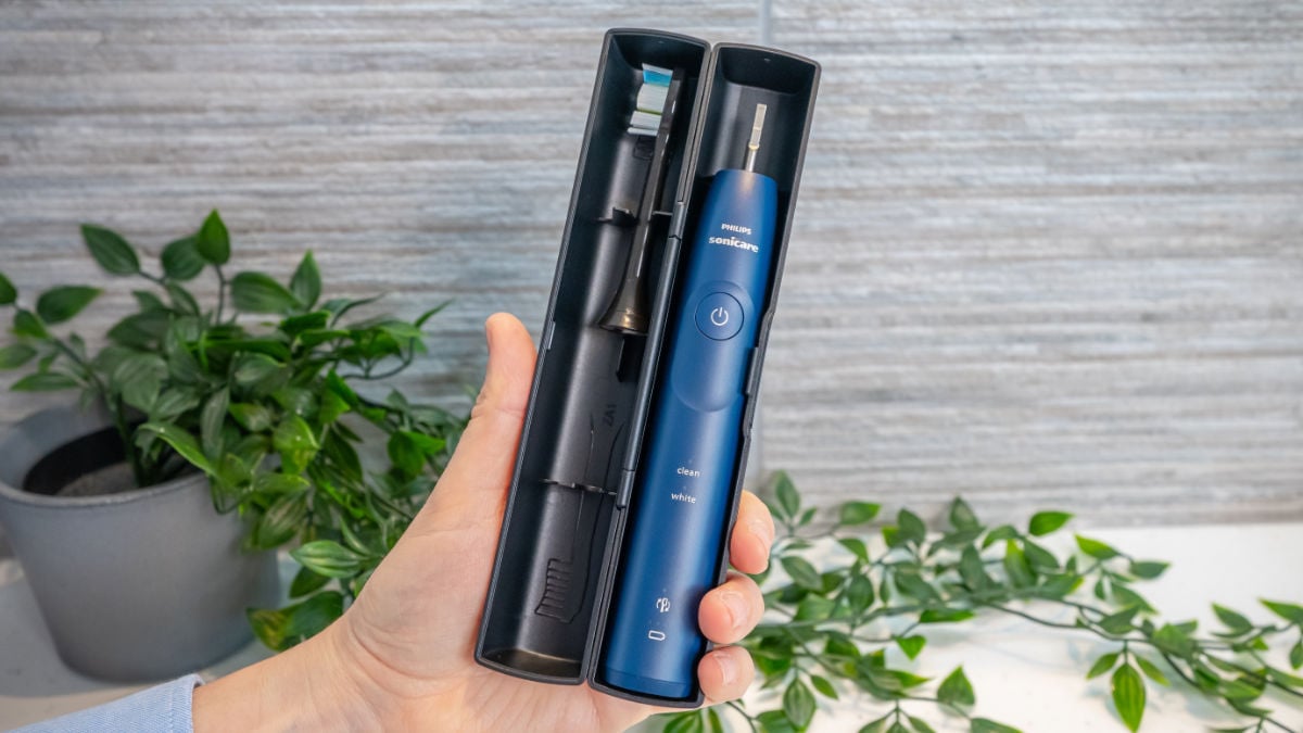 A hand holding the Sonicare 5500 travel case which is open to show the handle and head being stored