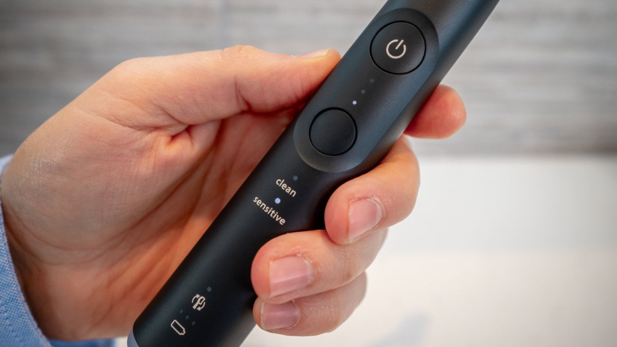 Hand holding Sonicare Series 6100 and showing close up of buttons
