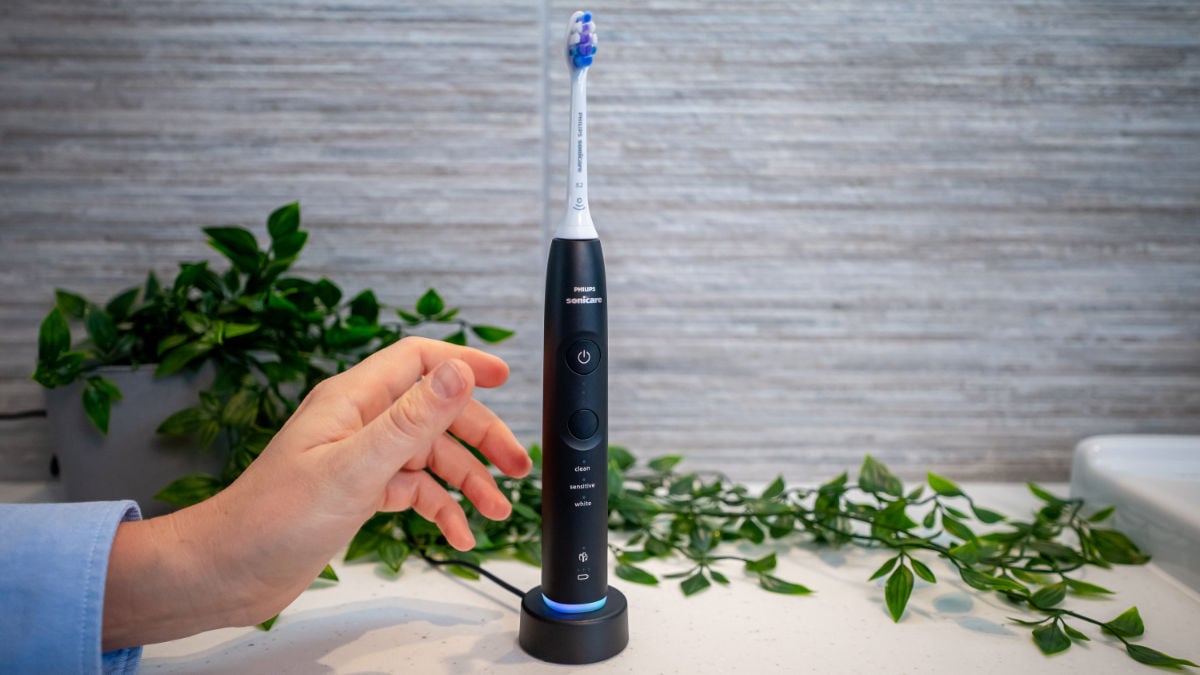 Hand placing Sonicare Series 6500 on charging stand