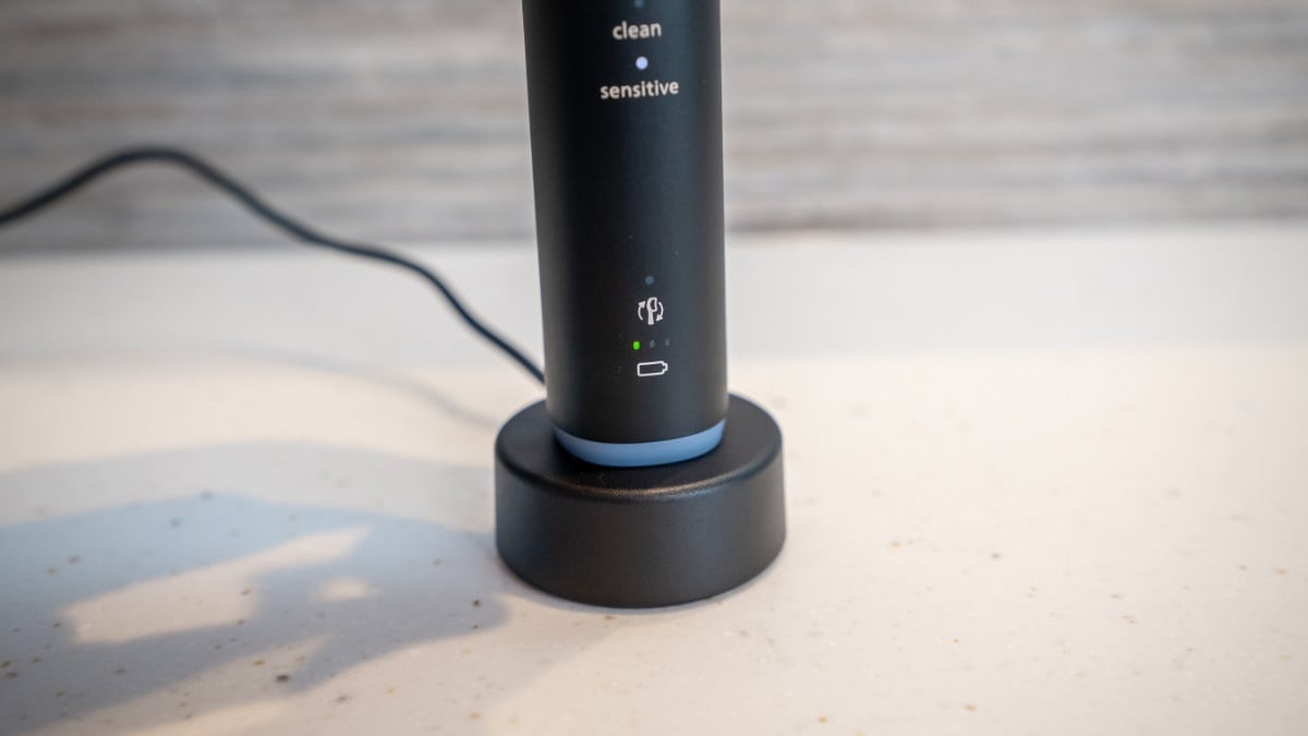 Sonicare Series 6100 being placed on charging stand and battery status indicator showing one bar illuminated