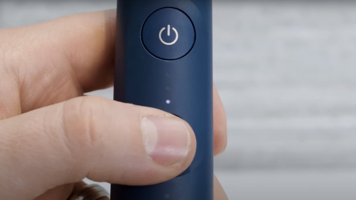 Thumb pressing button on Sonicare Series 7100