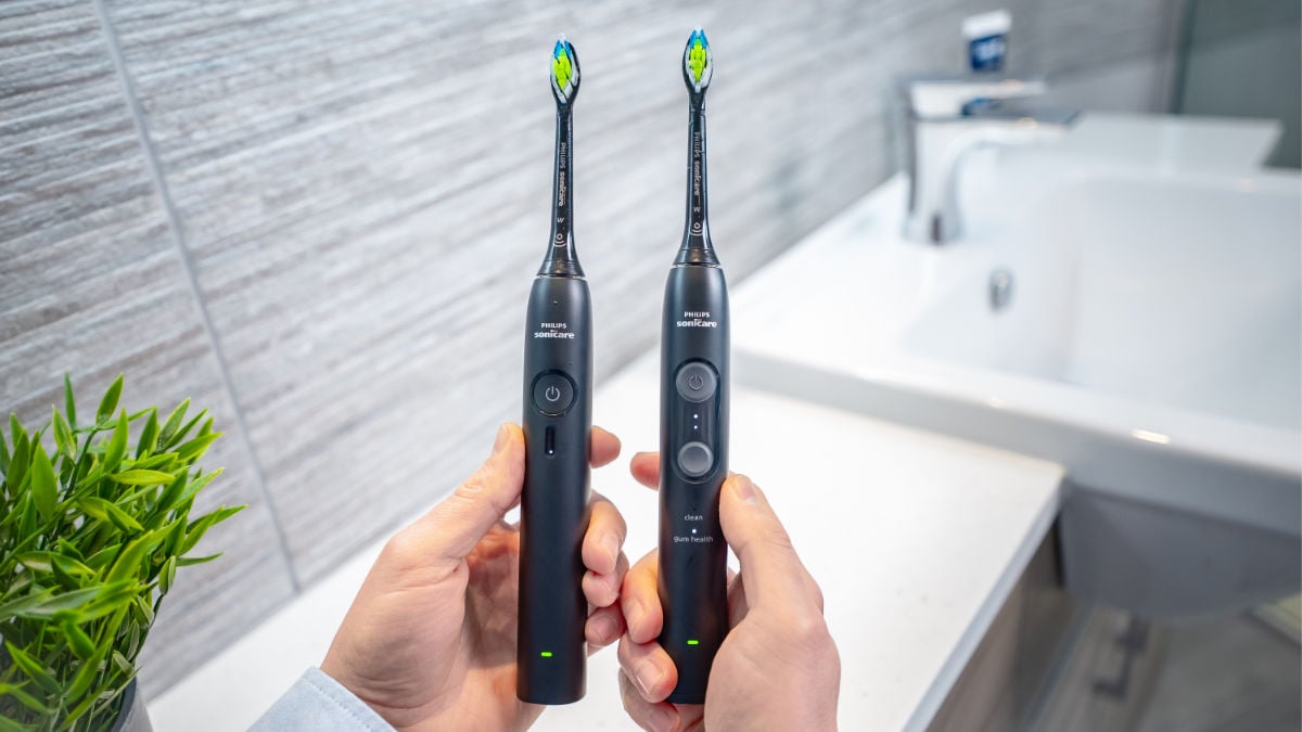 Sonicare 3100 and 4100 held next to each other showing LEDs for modes and intensities