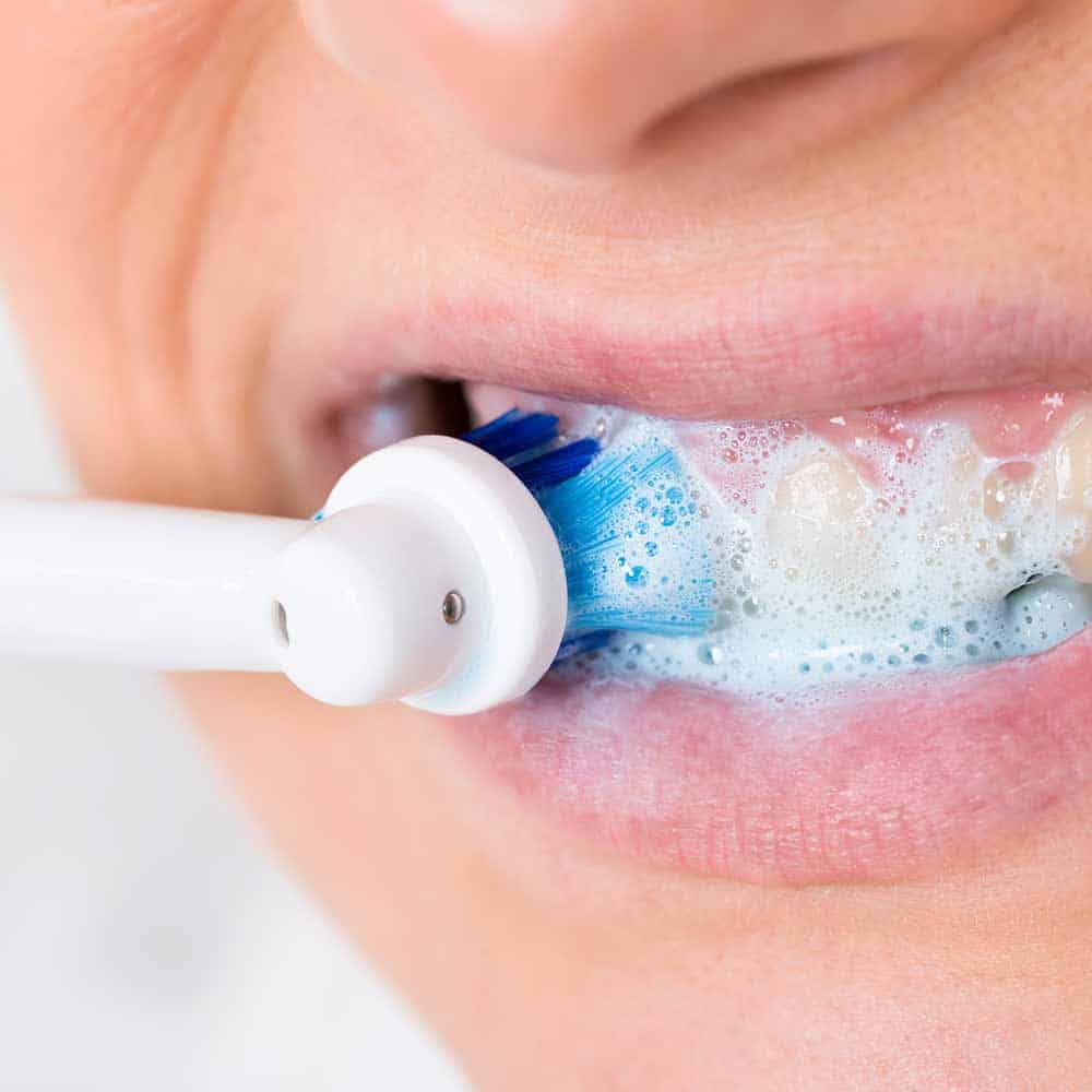 Close up of an electric toothbrush cleaning teeth