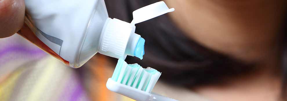 toothpaste being put on toothbrush