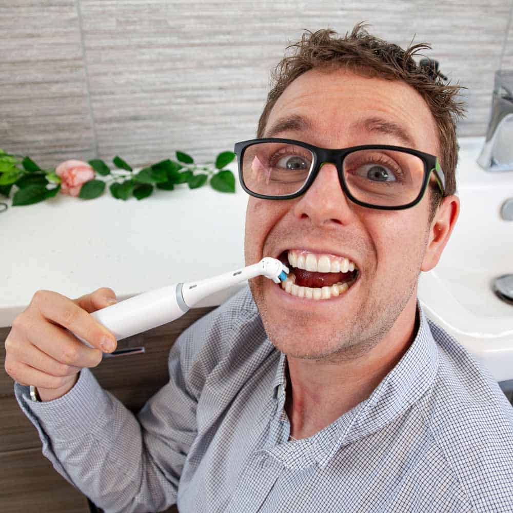 Man holding Oral-B iO Series 3 to their teeth