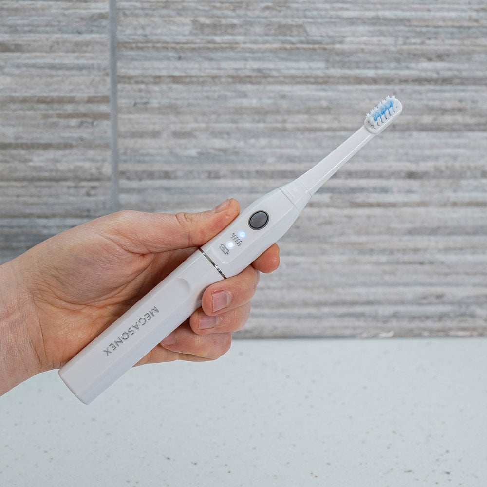White M8s Ultrasound toothbrush in the hand
