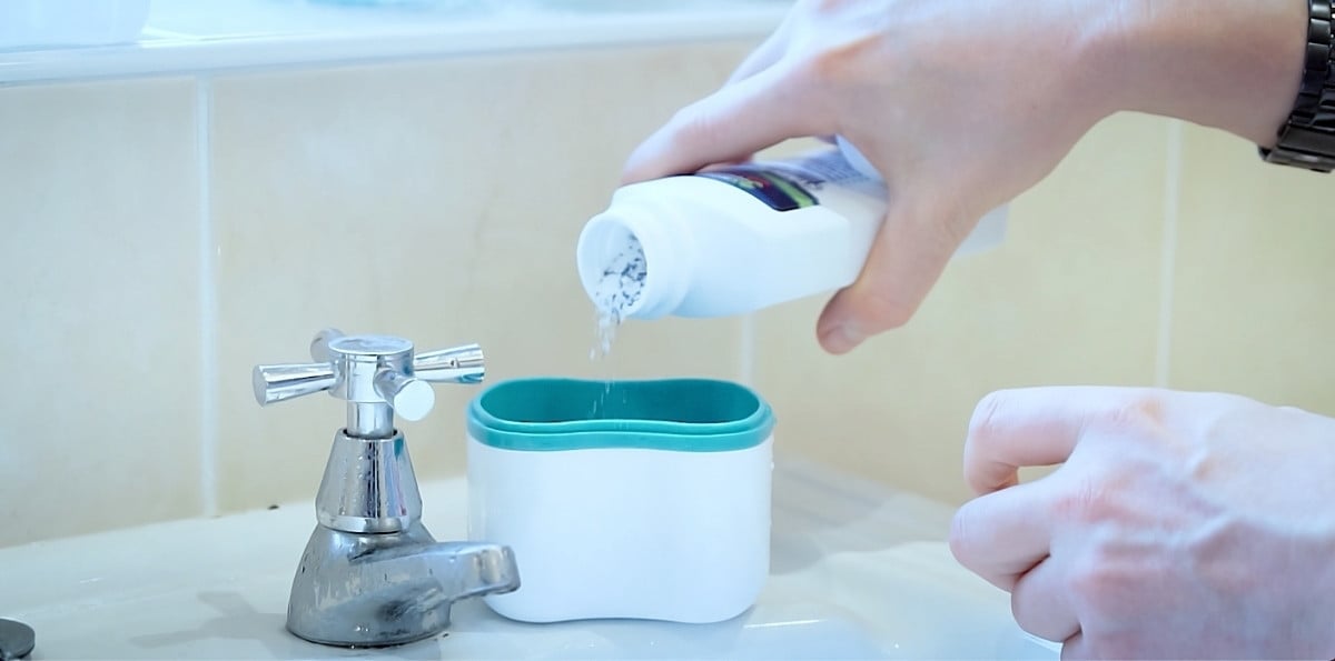 Denture cleaning solution being added to a denture bath