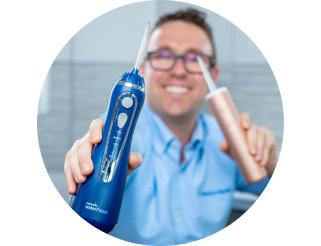 Jon Love holding water flosser to camera