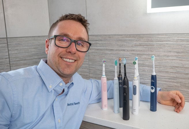 Electric Teeth Co-Founder Jon Love with various electric toothbrushes