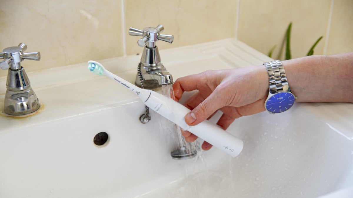 Sonicare 4100 Series being rinsed under tap
